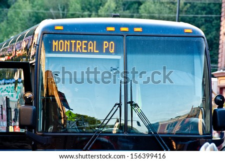 This bus is headed straight to Montreal. The stickers on the bus door prove that the bus has passed state inspections.