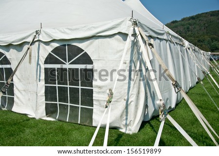 A large bright white entertainment tent contrasts with green grass.