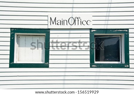 Two tiny windows, one shuttered over with wood, make the sign \
