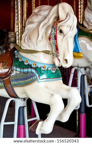 A brightly painted white carousel horse waits for a rider.