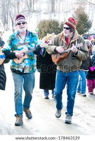Calais, Vermont, USA - February 19, 2012: Leaders of the town ukulele band provide music for the annual Mardi Gras parade in downtown Maple Corner, Vermont.