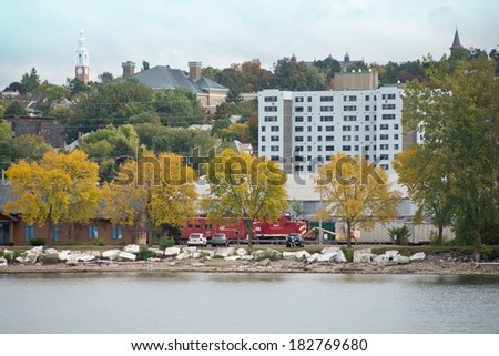 Burlington, Vermont, USA - September 27, 2013: A jogger runs down the waterside trail while a red train engine approaches from the other direction near the Pine Street Canal on an autumn afternoon.