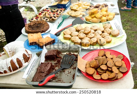 A bake sale is in full progress. All items for sale have been labeled with ingredients for the benefit of those with food allergies.