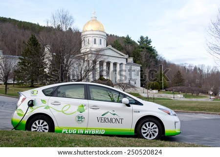 Montpelier, VT, USA - April 21, 2014: A plug-in hybrid vehicle is refueling on a warm spring evening at a parking lot outside the Vermont Statehouse in Montpelier.
