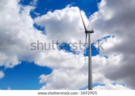 a big windmill with blue sky and clouds