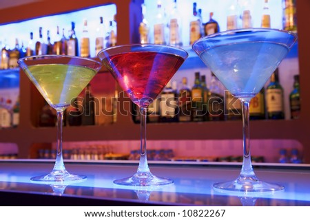 blue, red and yellow cocktail drinks on a bar