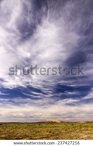 White clouds and blue sky above Moroccan green land.