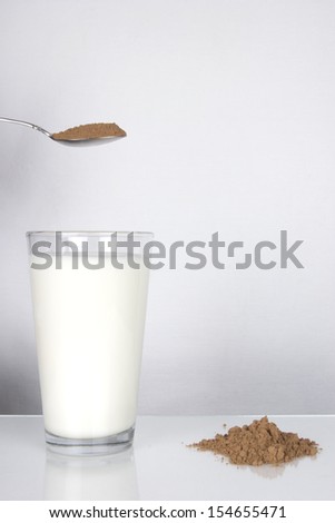 Glass of White Milk with Spoon and Powder