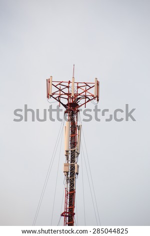Cell site, Telecommunications radio tower or mobile phone base station with atop the antennas isolated with white sky background.