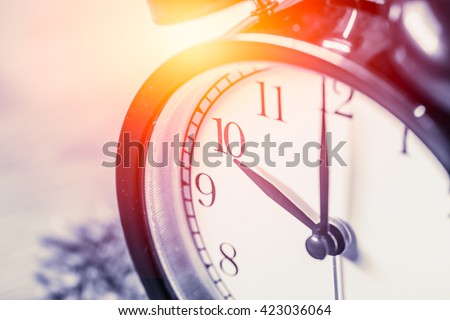 closeup vintage clock selective focus at number 10 o\'clock with sun light vintage color tone for postcard.