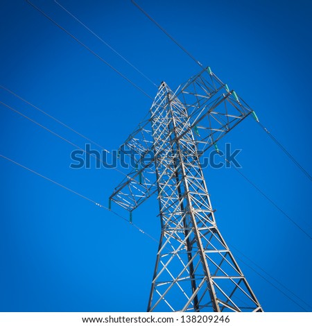 a long line of electrical transmission towers carrying high voltage lines
