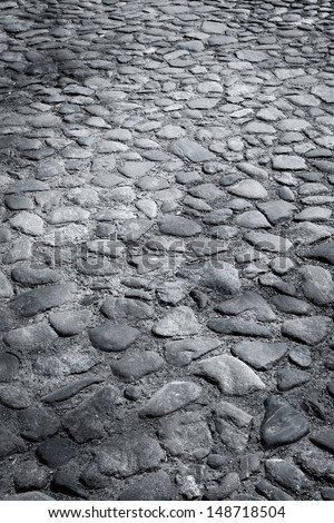 Closeup background texture of old wet cobblestone road