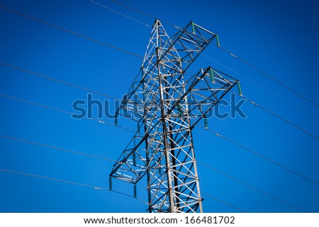 a long line of electrical transmission towers carrying high voltage lines