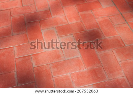 Red floor tiles with shadows from trees
