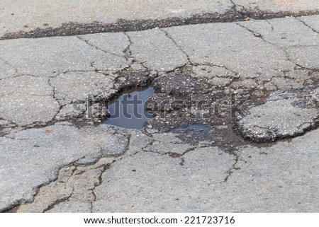 Bad old road, big hole in street asphalt