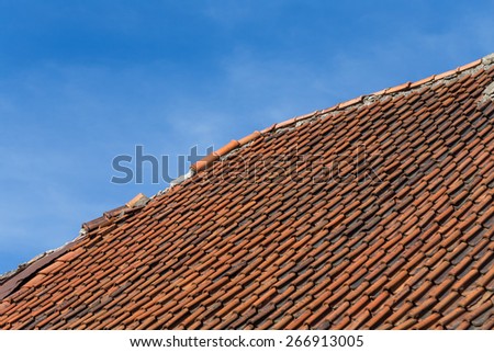 Broken terracotta tile on a roof of old house