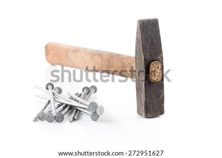 old hammer with wooden handle and some nails on white table