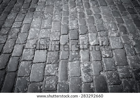 Old european cobblestone road close up in black and white