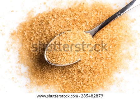 brown sugar in a spoon on white background