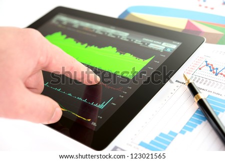 Hand on screen tablet pc with business information