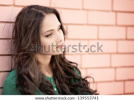 Young elegant woman in front of brick wall backround