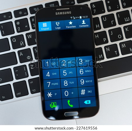 SIMFEROPOL, RUSSIA - NOVEMBER 01, 2014:  Keypad of Samsung Galaxy S4 over Apple Macbook Pro keyboard. Samsung Galaxy S4 is an Android smartphone produced by Samsung Electronics.