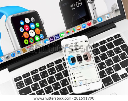 Moscow, Russia - May 26, 2015: Apple watch on iPhone 6 and Macbook display. Apple Watch is a smartwatch developed by Apple Inc.