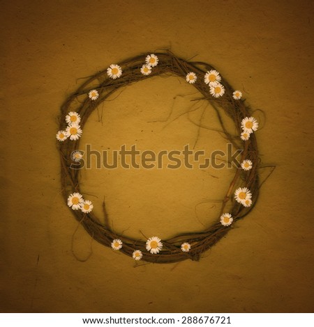 Beautiful and sweet round frame from natural flowers daisies and roots nice for romantic text or love notice, sepia spectrum of colors.