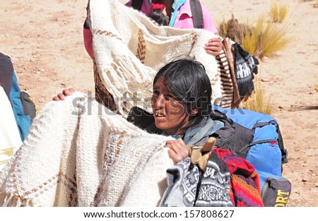 SAN ANTONIO DE LOS COBRES, ARGENTINA - APRIL 27: Woman-indian sells clothes during the train stop in Andes on April 27, 2013, Argentina. 	 Altitude approx. is 4000 m above sea level.