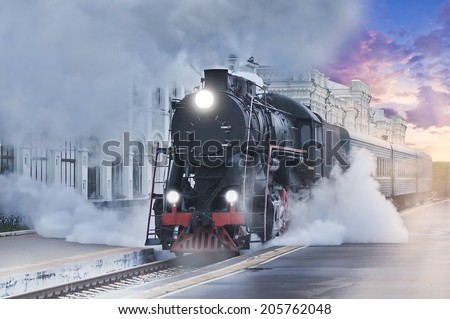 Retro steam train departs from the railway station at sunset.