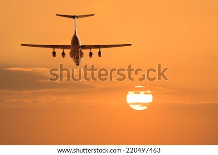 Flight of the cargo plane on the sunset background.