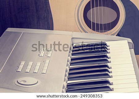 Digital midi keyboard and acoustic guitar in the studio.