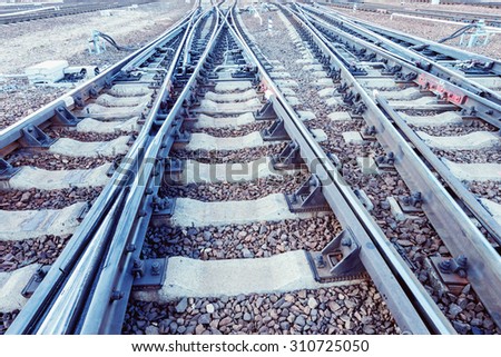 Railway tracks on the big station at sunset time.