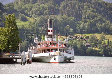 Vitznau, Switzerland - June 10, 2010: The passenger tourist steam boat leaving pier in central Switzerland.