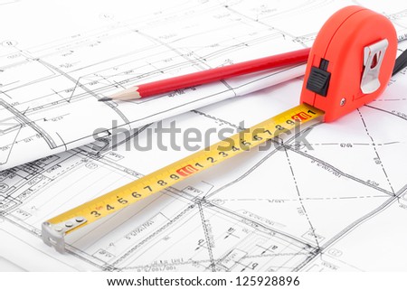 Architectural drawings, a tape measure and a pencil  in perspective.