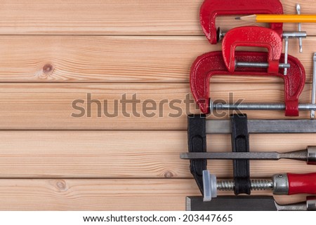 Woodworking tools and a pencil on a wooden background.
