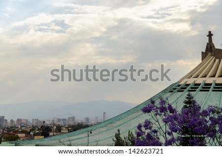 Roof of the Basilica of our Lady of Guadalupe with Mexico City skyscrapers in the background
