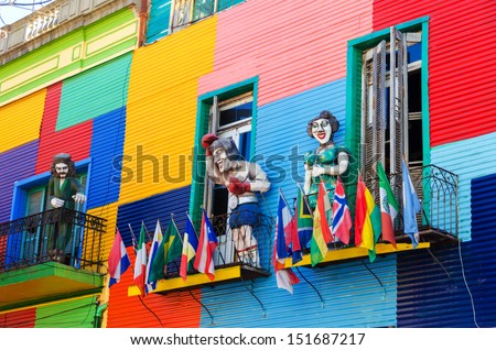 A colorful building in La Boca neighborhood of Buenos Aires with statues and flags
