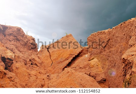 Wall cliff - sandy brown soil with sky and sunlight.