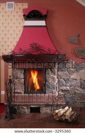 A cozy, warm indoor fireplace with a crackling fire blazing