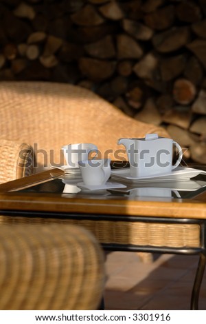 Pitcher and cups for coffee sitting on an outdoor patio