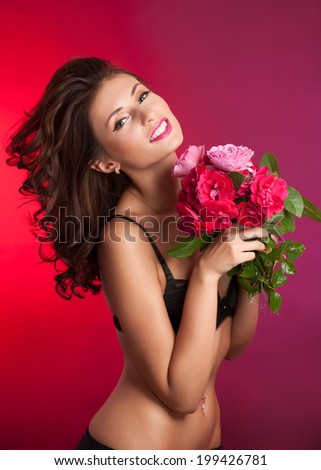 Happy smiling woman with bouquet of red and pink roses.