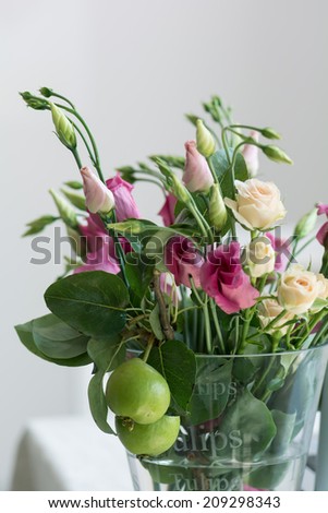 Pink  and white lisianthus flowers bunch in a glass vase on the table, narrow deep of field.