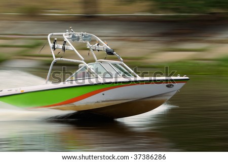 Speed motor boat cruising in the river. Motion blurred panning shot.