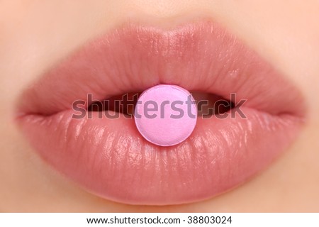Close-up of pink pill in woman\'s mouth