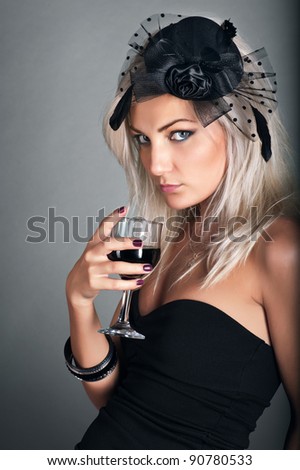 Young woman in bonnet with a glass of red wine.