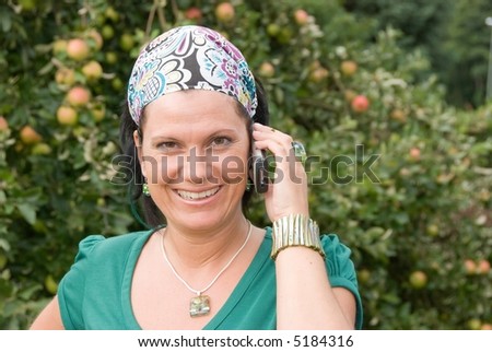 A pretty woman is smiling while talking on a cellphone