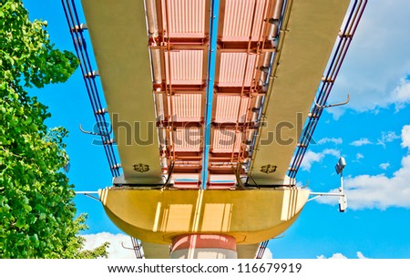 Ecological road to nature. Monorail over trees on blue sky background.