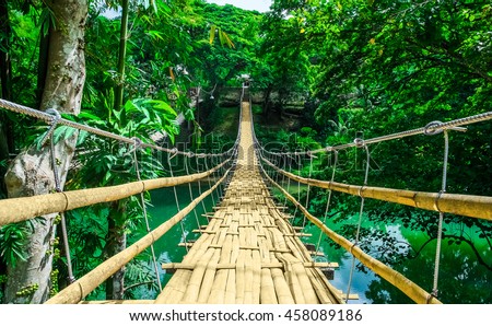 Bamboo pedestrian hanging bridge over river in tropical forest, Bohol, Philippines, Southeast Asia