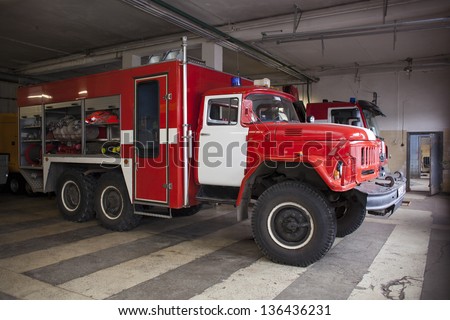 A fire truck is parked in the bay with all of the fire fighting equipment and gear ready to go.